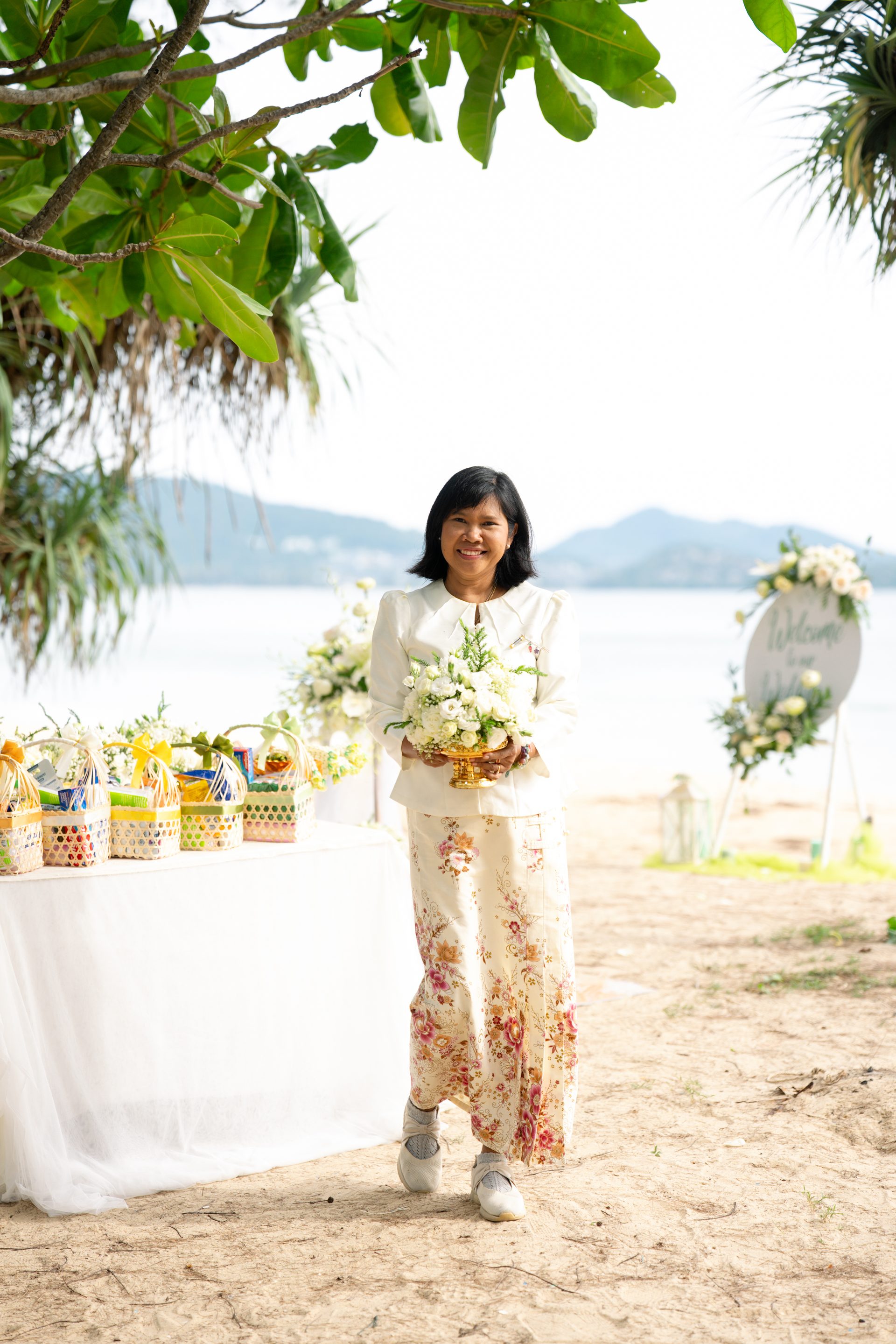 Supparin walking through a Barefoot beach ceremony setup, checking the final details