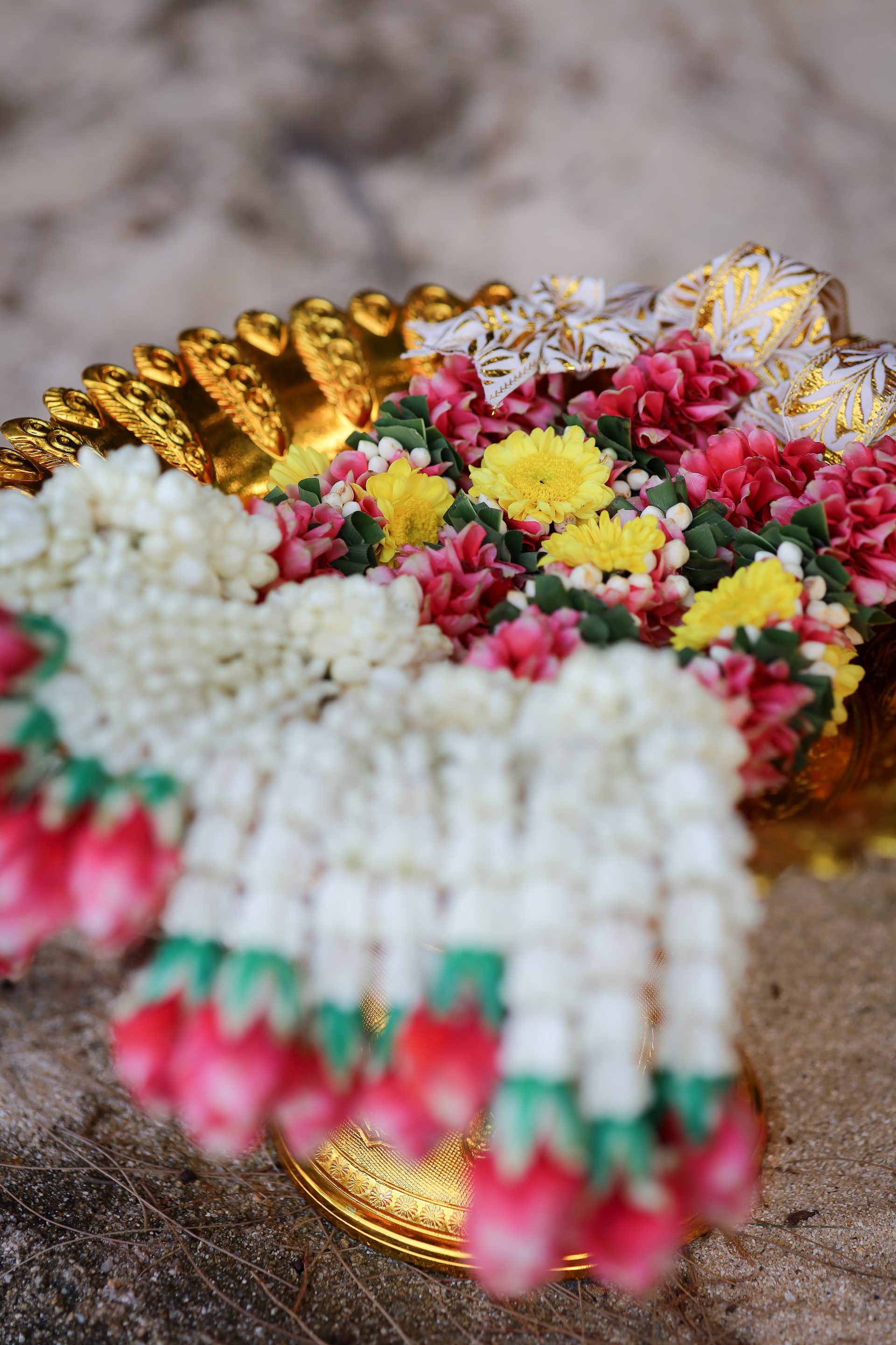 A traditional Thai blessing garland placed on a couple during a symbolic Phuket beach ceremony
